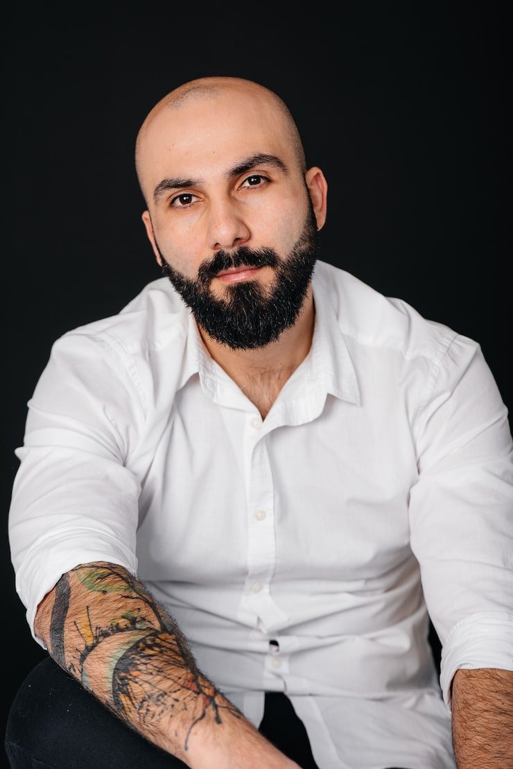 young-bearded-man-white-shirt-tattoos-stands-black-background_180601-9297